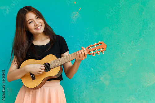 Girl playing buitar blue background