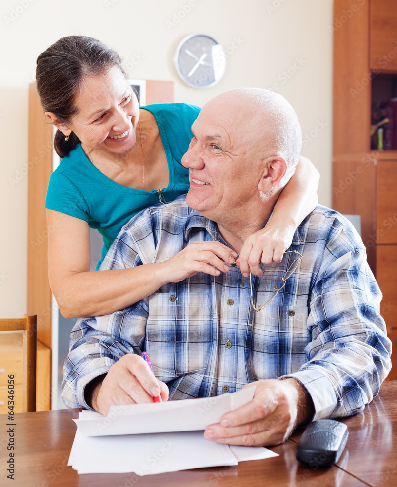 Obraz premium Happy mature couple fills in paper documents