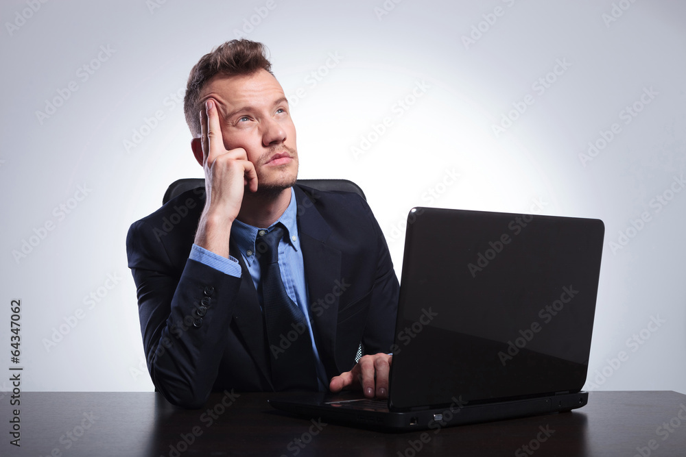 business man thinks behind laptop business man thinks behind laptop