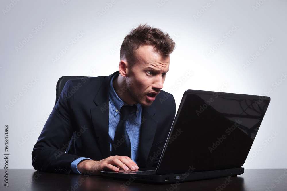 business man looks surprised at laptop business man looks surprised at laptop