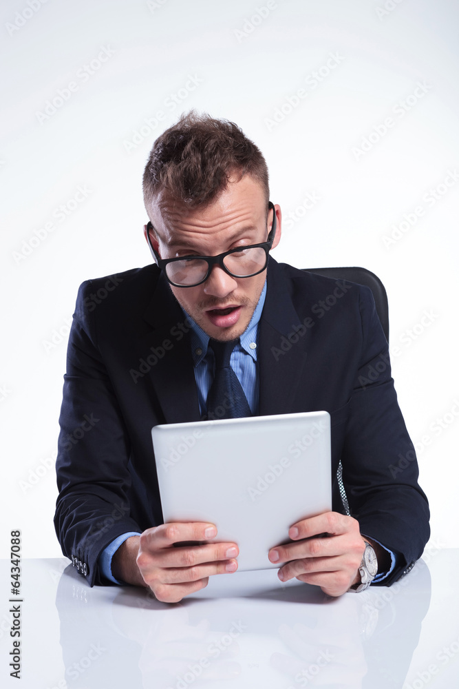 business man looks surprised at his tablet business man looks surprised at his tablet