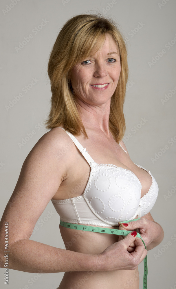 Woman in white bra taking underband measurement Stock Photo