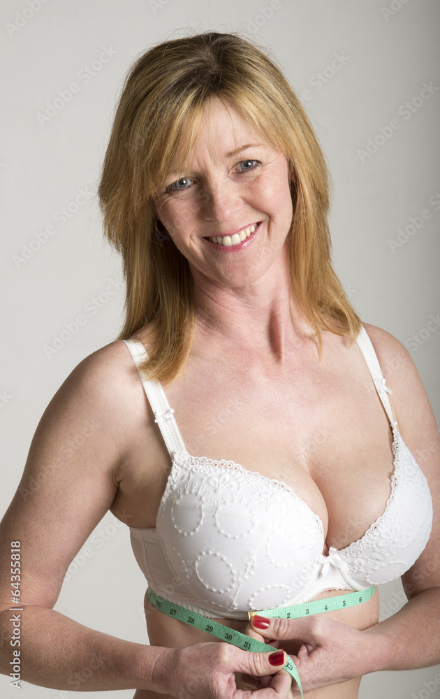 Woman in white bra taking underband measurement Stock Photo