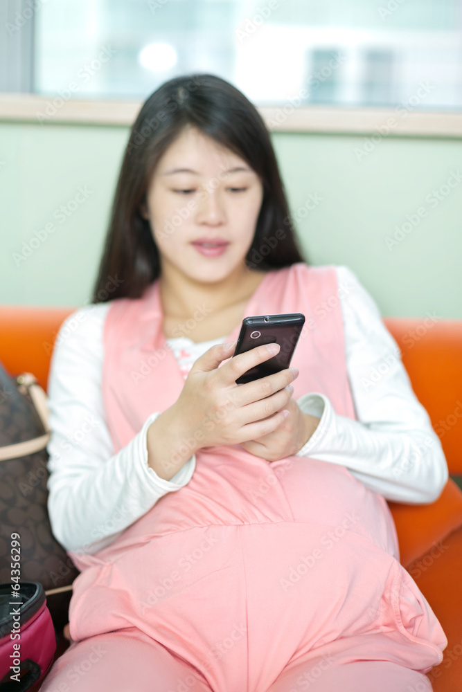 Photo of pregnant woman lying and looking at cellphone Photo of pregnant woman lying and looking at cellphone