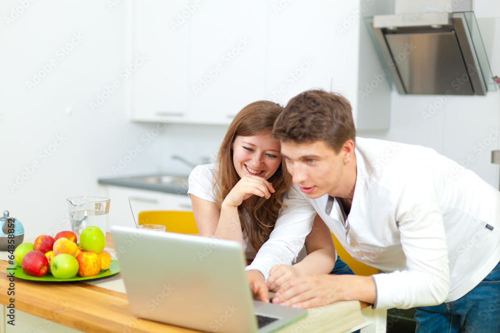 Frau mit laptop in der küche Frau mit laptop in der küche