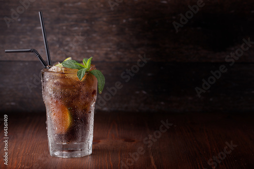 Cuba Libre Drink with lime on a wooden table