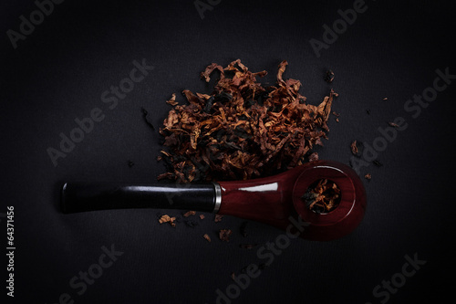 pipe and tobacco on  black background