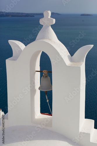 Bell tower of church above the beautiful blue bay at Santorini