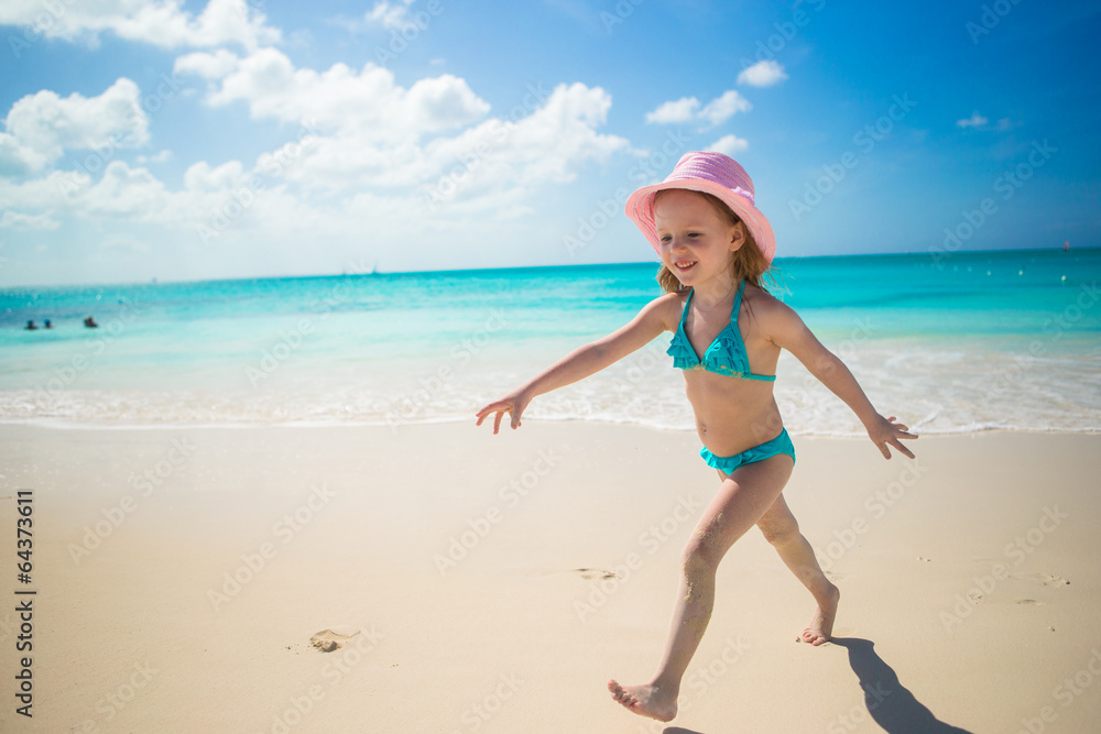 Little girl running along the beach and enjoy summer holidays Little girl running along the beach and enjoy summer holidays