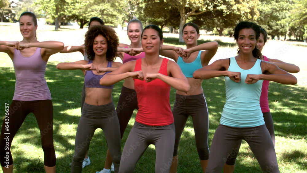 Fitness class doing squat sequence together Fitness class doing squat sequence together
