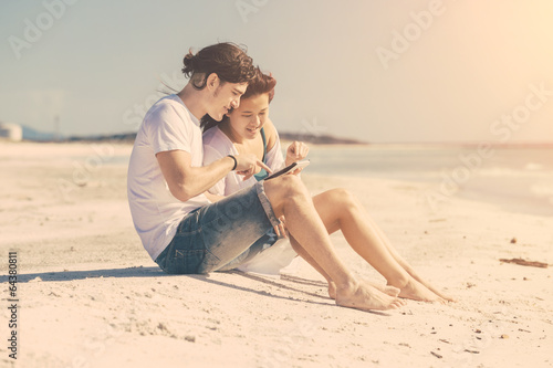 Young Couple at Seaside with Digital Tablet
