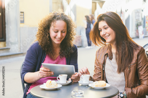 Canvas Print Girls Using Digital Tablet while Having Breakfast