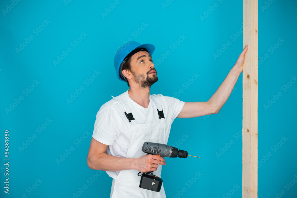 Workman in a hardhat holding a drill Workman in a hardhat holding a drill