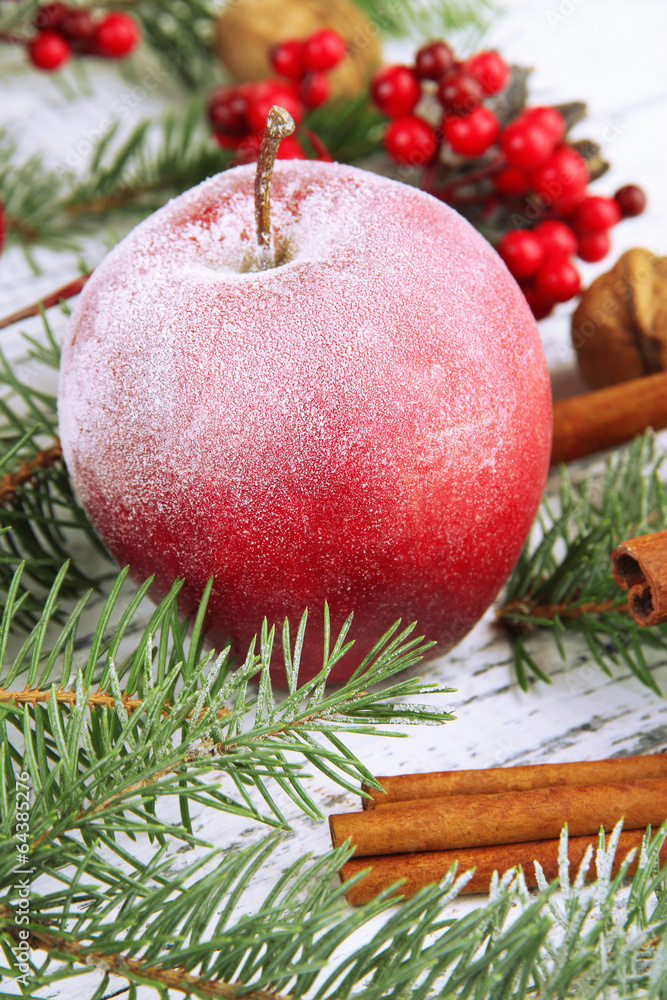 Red apple with fir branch on table close up Red apple with fir branch on table close up