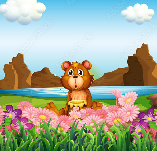 A cute bear near the flowers at the riverbank