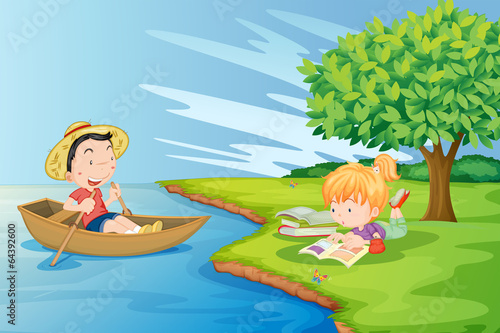 A boat with a boy and a girl studying at the riverbank