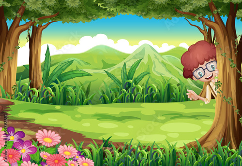 A kid hiding at the tree inside the forest