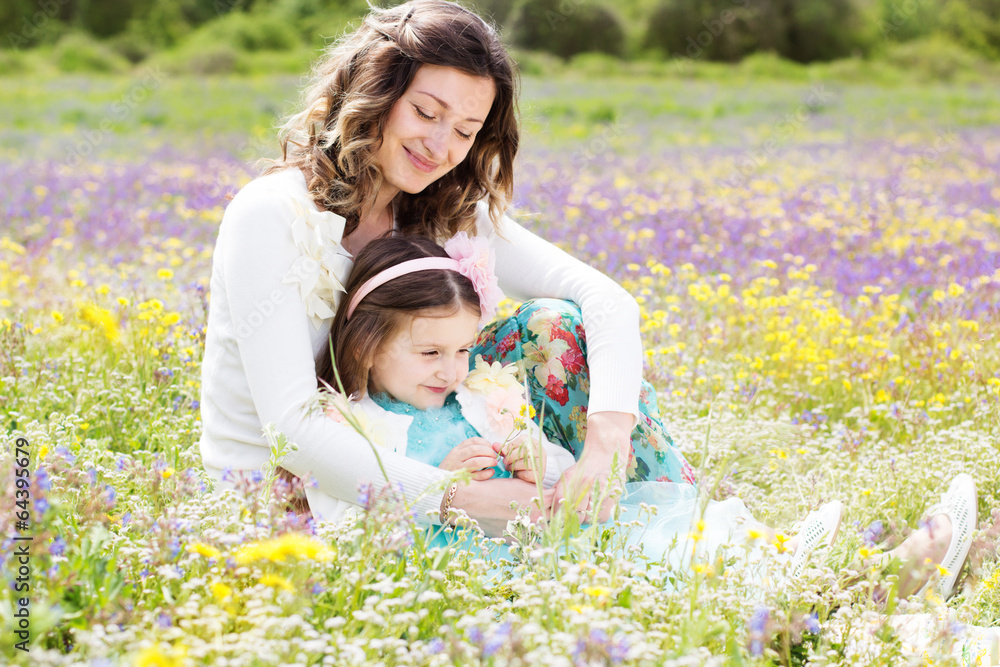 Mother and daughter in field with colorful flowers Mother and daughter in field with colorful flowers