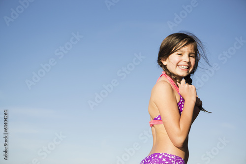 A young child in a bikini with plaited hair. photo