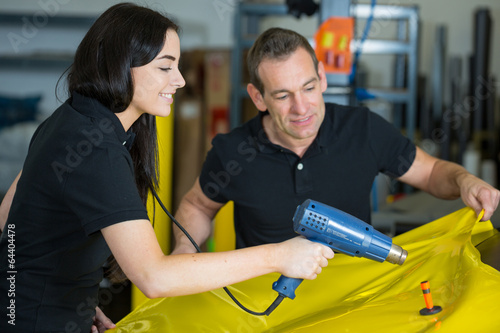 Car wrappers using heat gun to prepare vinyl foil