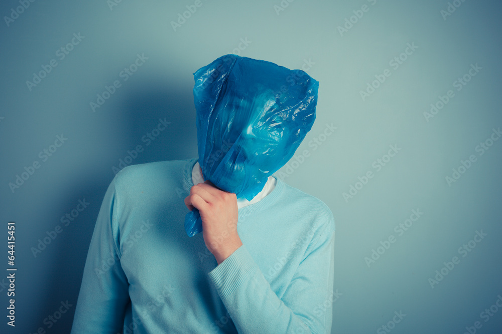 Man with plastic bag over his head suffocating Photos | Adobe Stock