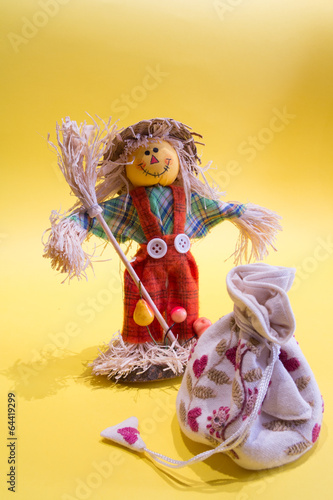 A funny colorful scarecrow with a bag