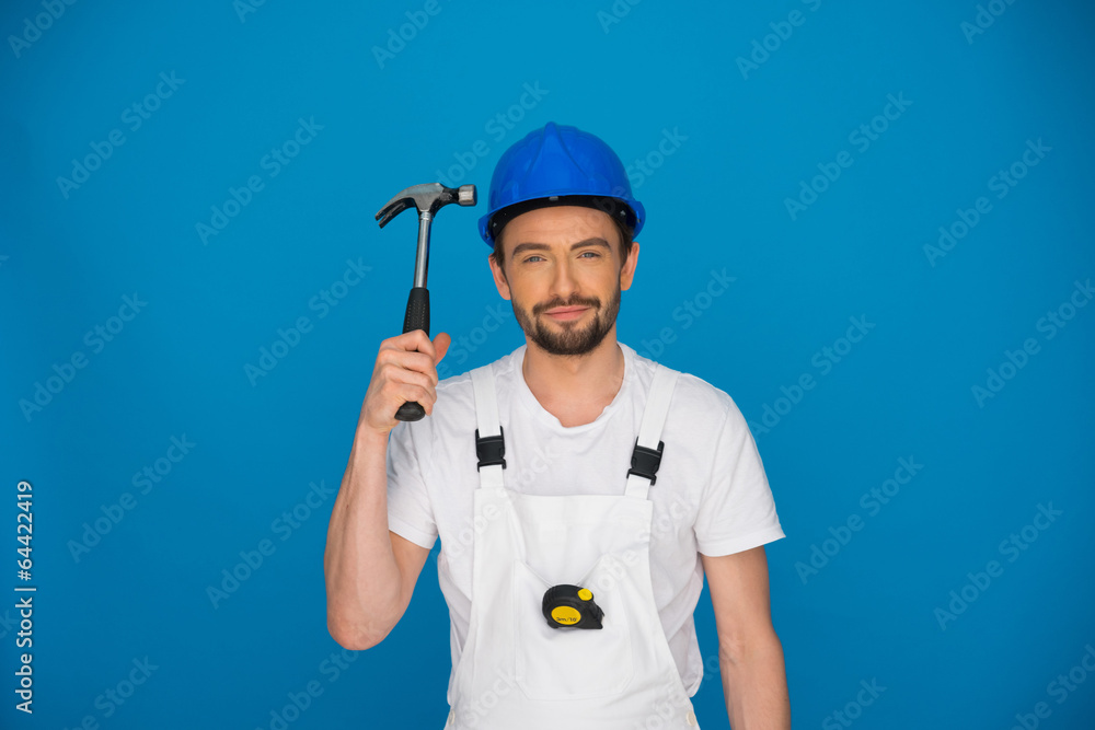 Smiling workman holding up a hammer Smiling workman holding up a hammer