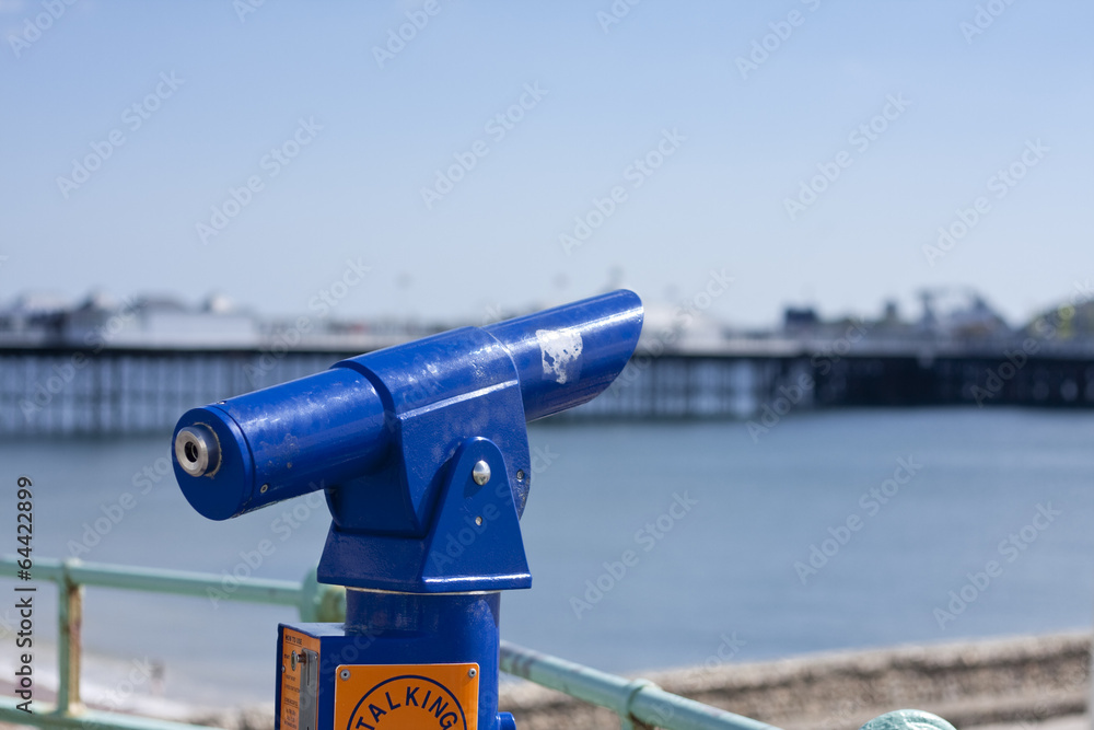 Blue telescope with Brighton Pier in background Blue telescope with Brighton Pier in background