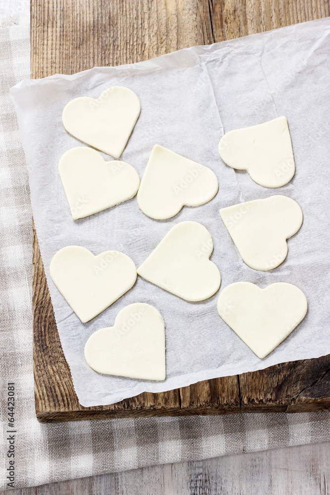 Obraz premium Making puff pastry cookies in heart shape filled with strawberri