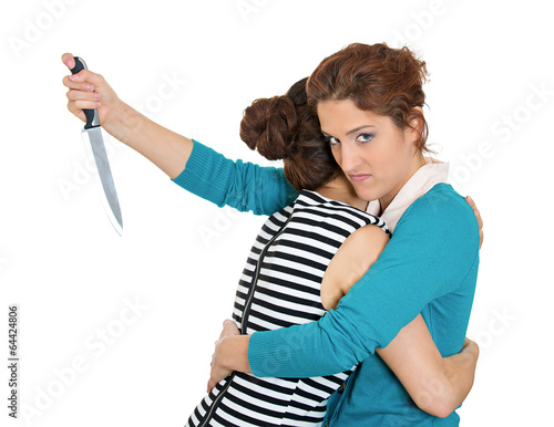 Back stabber woman hugging lady, at same time trying to stab her