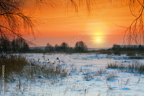 Rural winter snowy landscape at sunset