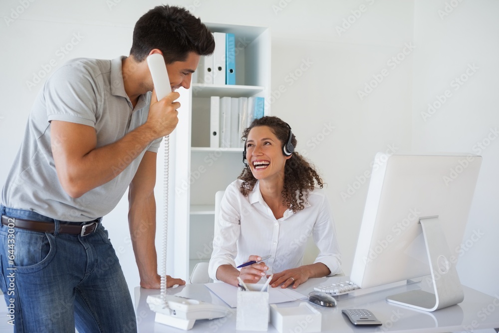 Casual business team laughing together at desk Casual business team laughing together at desk