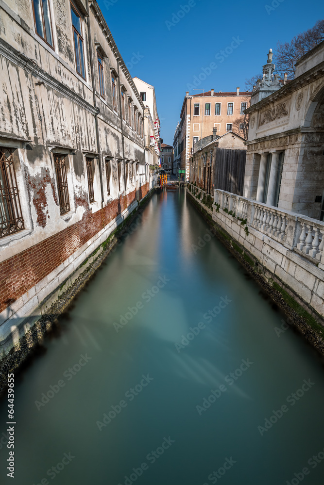 Narrow Canal Among Old Colorful Brick Houses in Venice, Italy