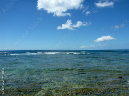 Shallow ocean waters with coral and small waves breaking in the