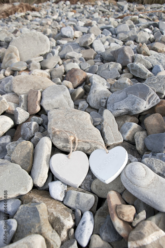 two wooden heart in a rocky beach two wooden heart in a rocky beach