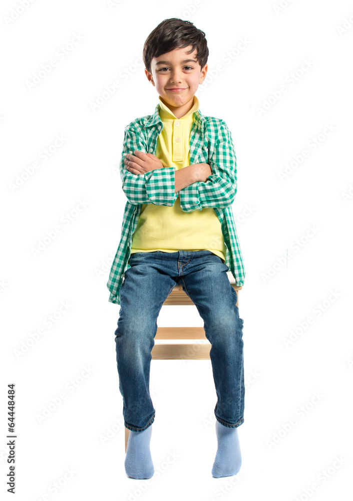 Happy brunette kid on wooden chair over white Happy brunette kid on wooden chair over white