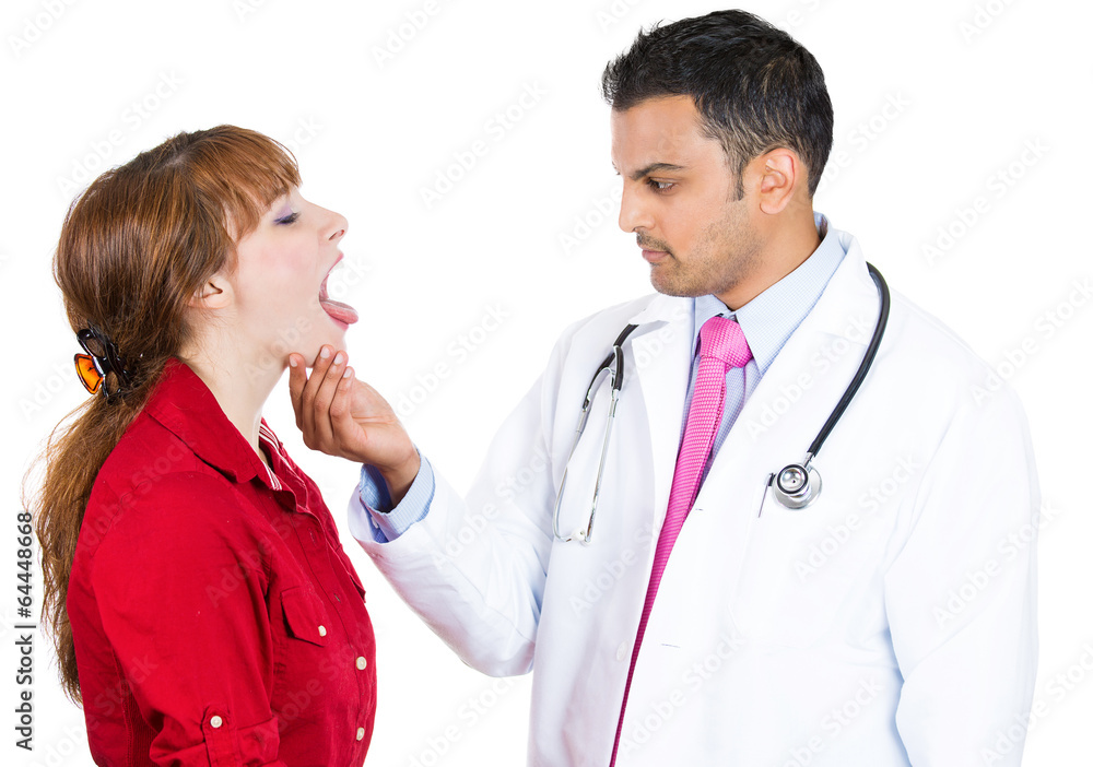 Throat exam performed on young female patient by a doctor Throat exam performed on young female patient by a doctor