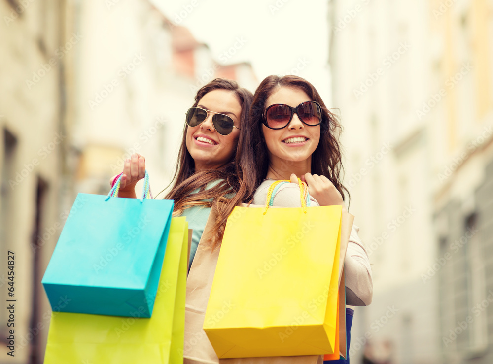 two girls in sunglasses with shopping bags in ctiy