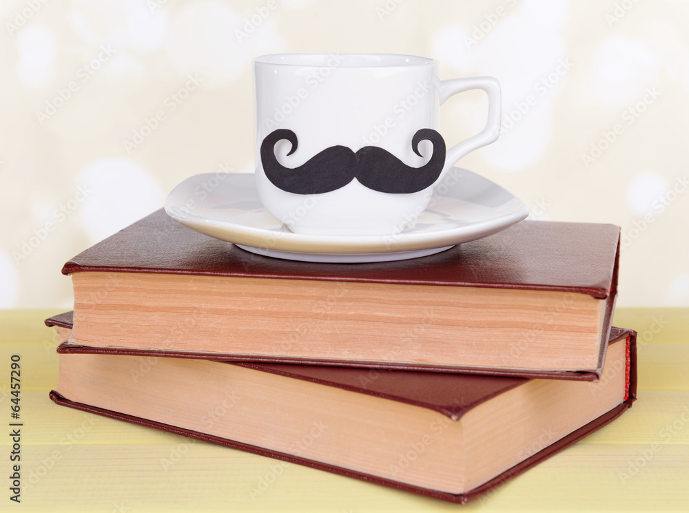 Cup with mustache on table on light background Cup with mustache on table on light background