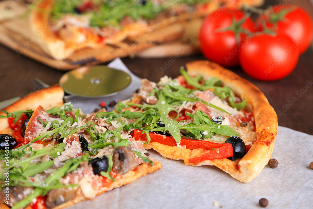 Pizza with arugula on cutting board, on color wooden background Pizza with arugula on cutting board, on color wooden background