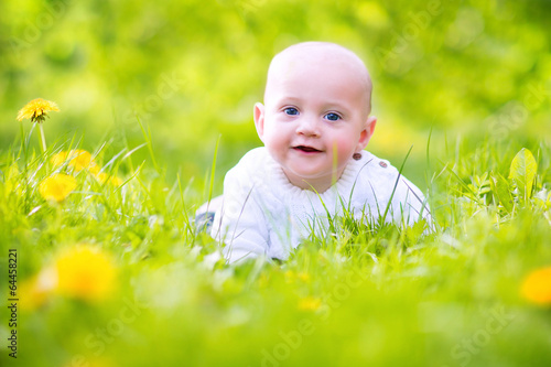 Cute funny baby in blooming spring apple garden