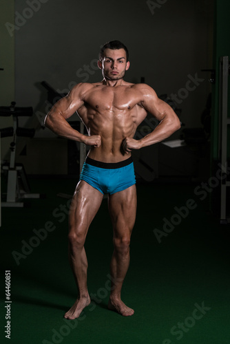 Bodybuilder Performing Front Lat Spread Poses