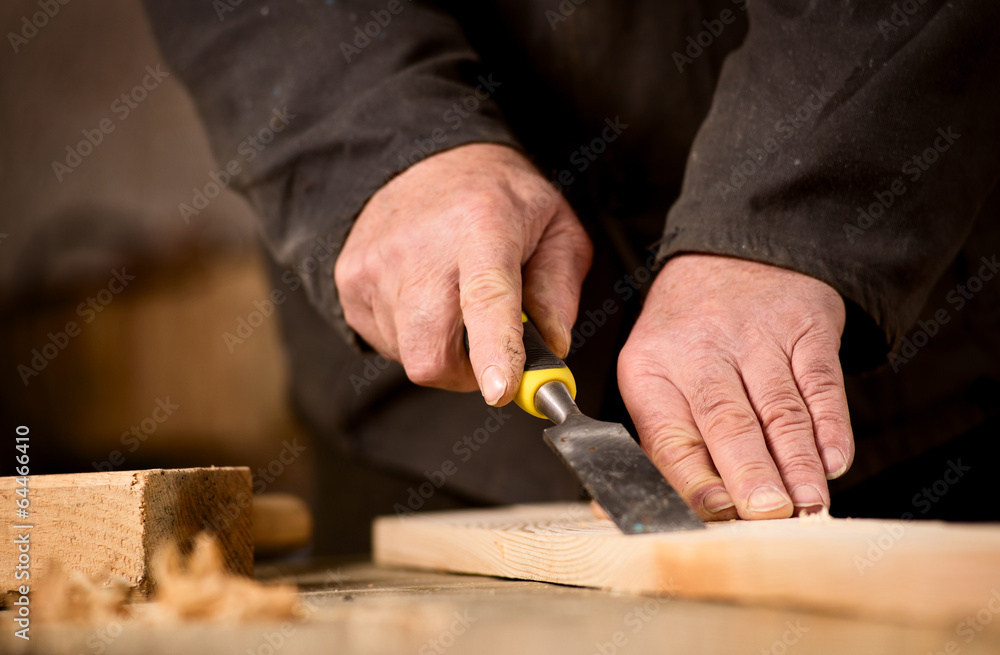 Carpenter using a chisel on a plank of wood Carpenter using a chisel on a plank of wood