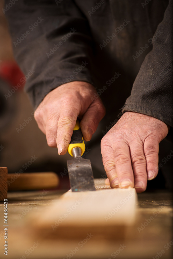 Carpenter using a chisel on a plank of wood Carpenter using a chisel on a plank of wood
