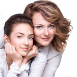 Attractive happy mother and smiling teenage daughter