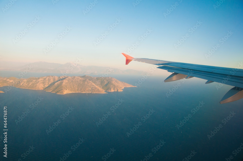 View from the airplane over the sea, the mountains, the wing View from the airplane over the sea, the mountains, the wing