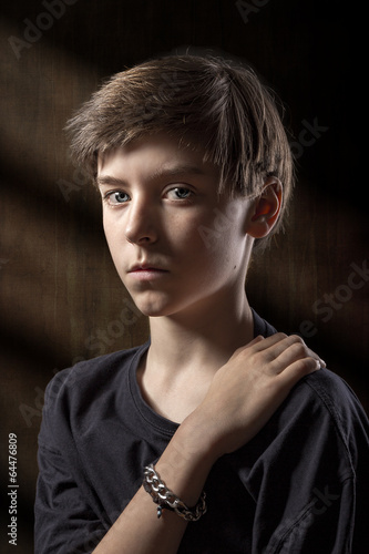 portrait of a male teenager with brown background and light stri