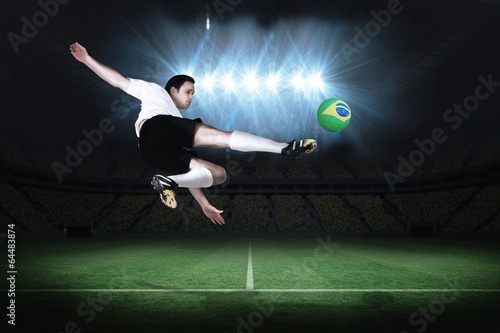 Football player in white kicking © WavebreakMediaMicro