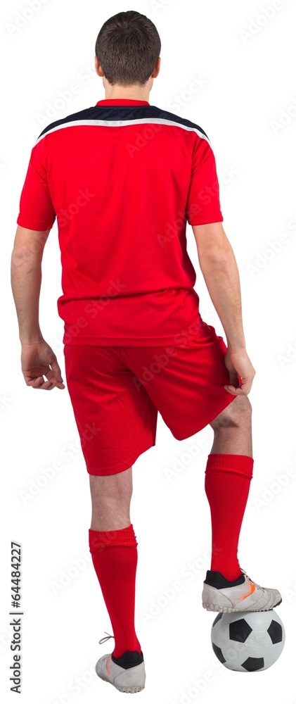 Fototapeta premium Football player wearing red gear standing with ball