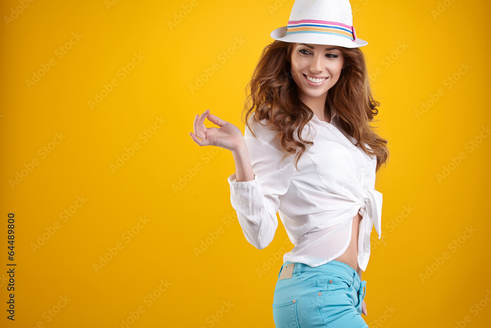 Young Woman with spring hat against yellow background Young Woman with spring hat against yellow background